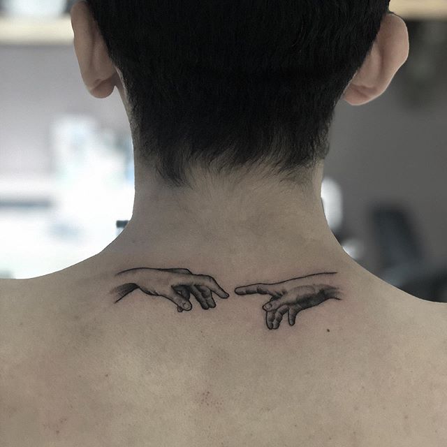Black tattoo of hands on the back of the neck