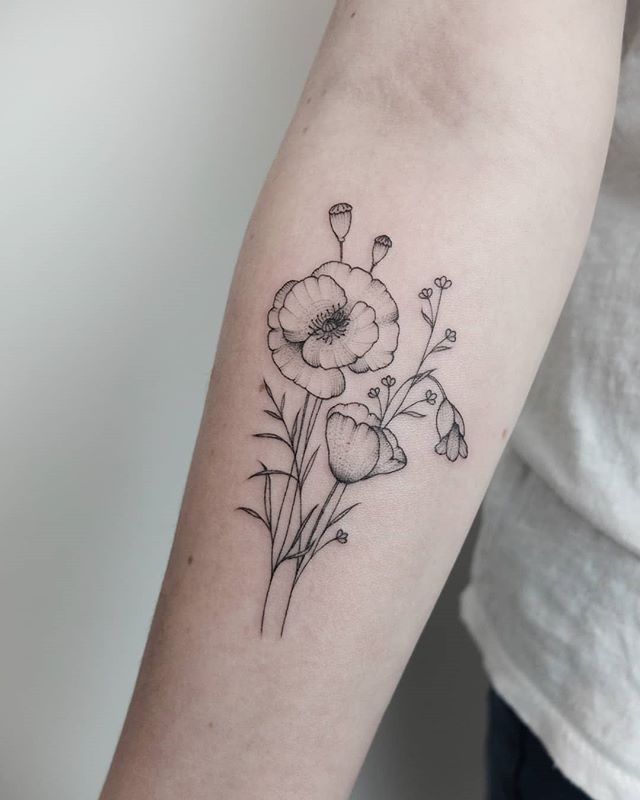 Black tattoo of wild poppies on the right hand