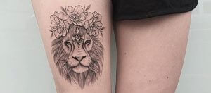 Dot work tattoo of a lion with flowers on the right leg