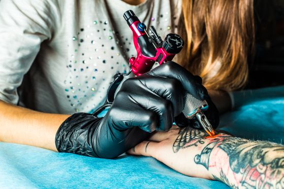 Girl making a tattoo on hand