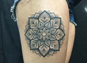 Mandala tattoo of a flower on the right leg