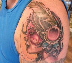 Neotraditional tattoo of a woman with feather on the left shoulder