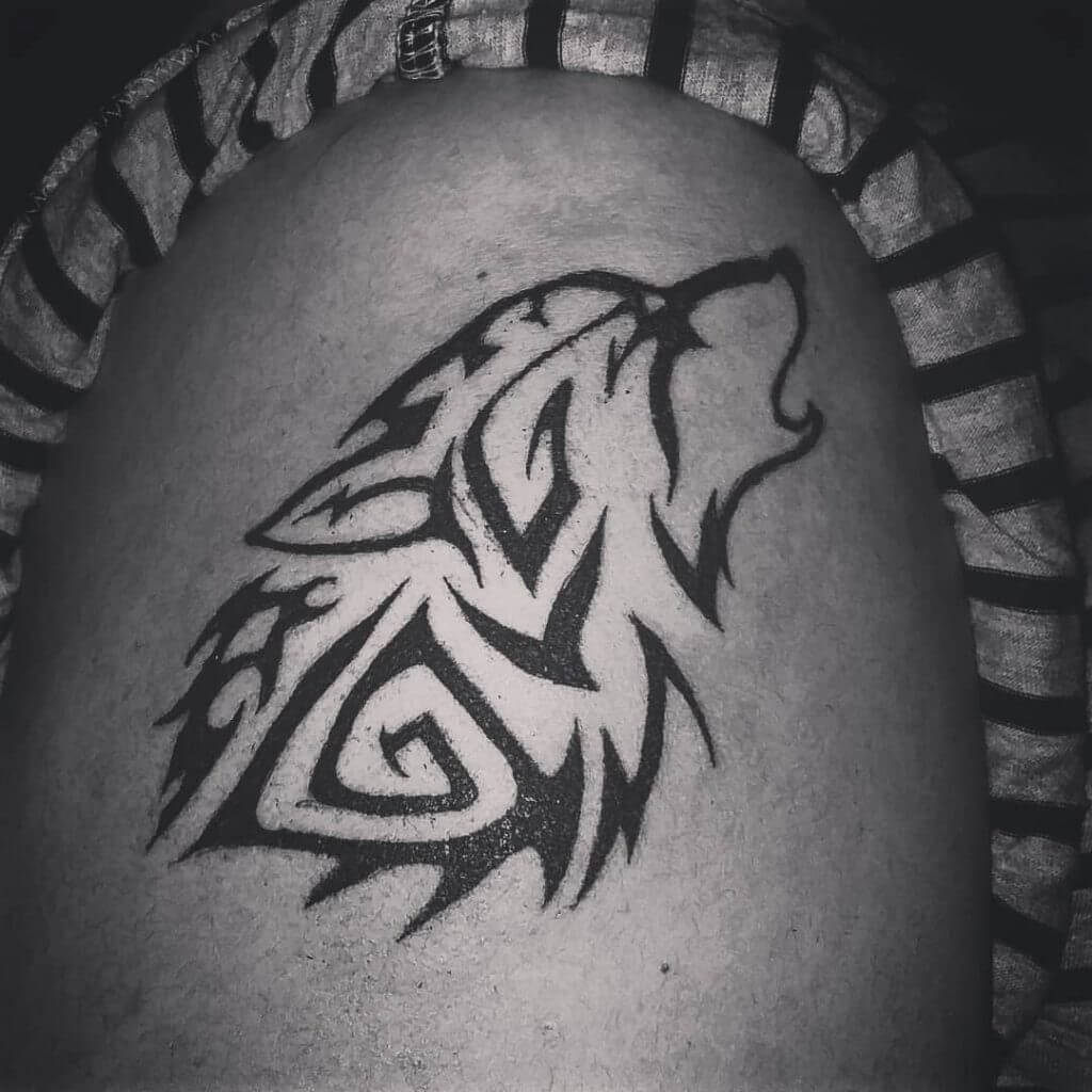 Black Male tattoo of a wolf on the right shoulder