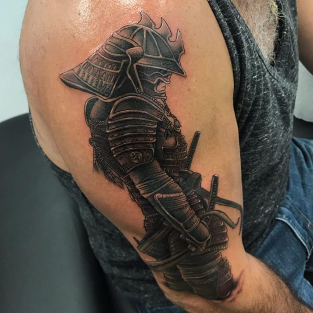 Black Tattoo of a male Warrior on the right shoulder