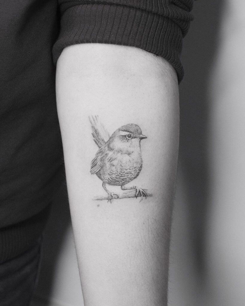 Black Bird tattoo on left forearm