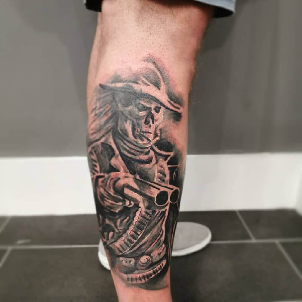Male tattoo of a Cowboy with a gun on the right calf
