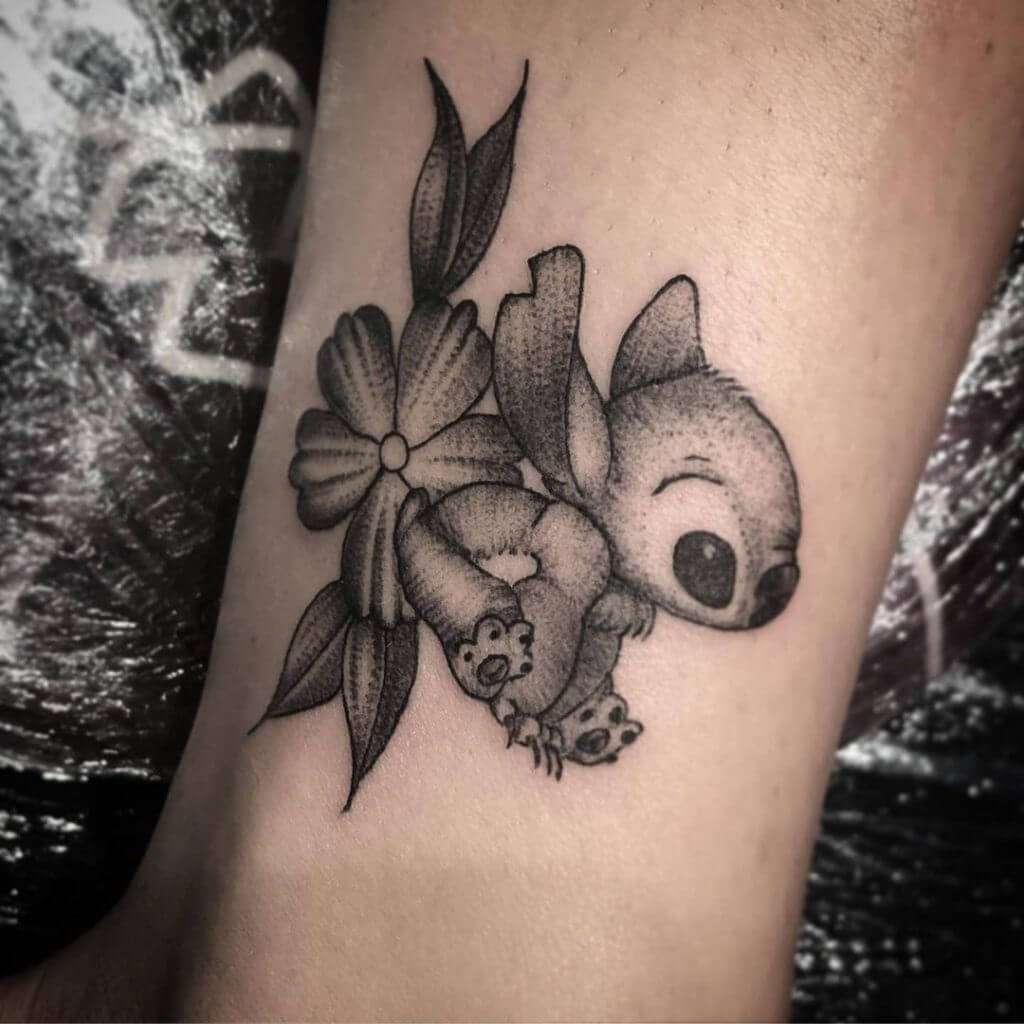 Black Small Cartoon Tattoo of Stitch and a flower on a foot