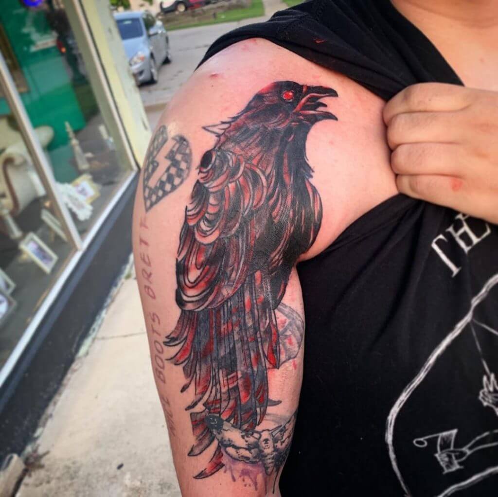 Bird tattoo of a crow on the right shoulder