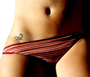 Intimate tattoo of a scorpion in the pubic zone