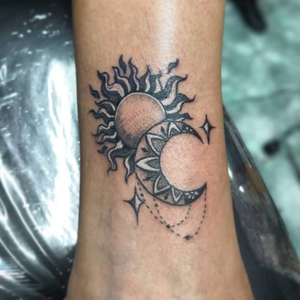 Black Sun tattoo with a moon on the forearm