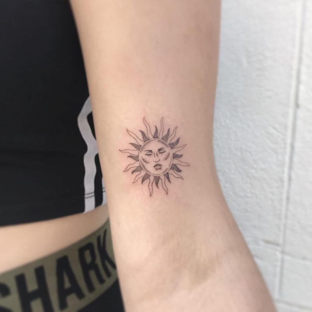 Black Sun tattoo on the left arm