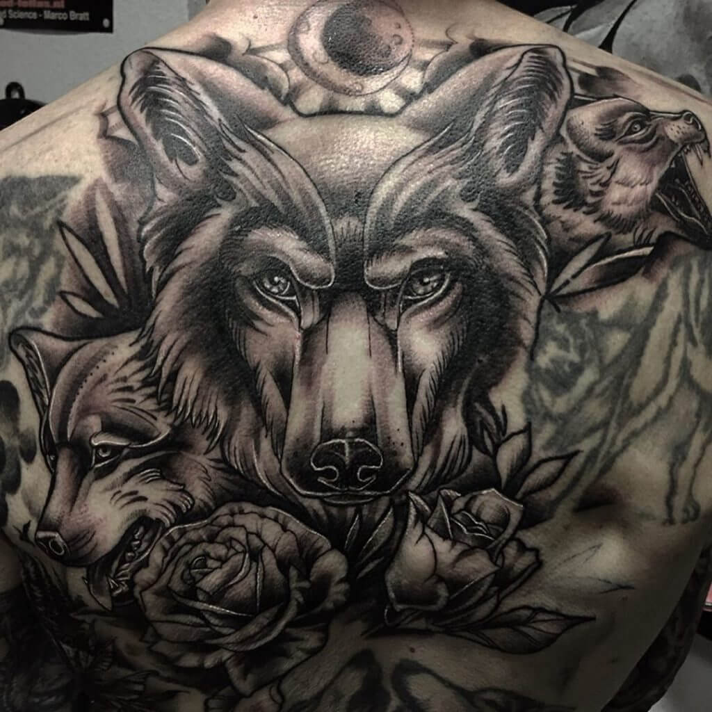 Mens black and gray neotraditional tattoo of wolfs and roses on the back