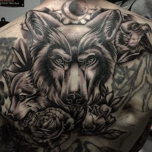 Male black and gray neotraditional tattoo of wolfs and roses on the back