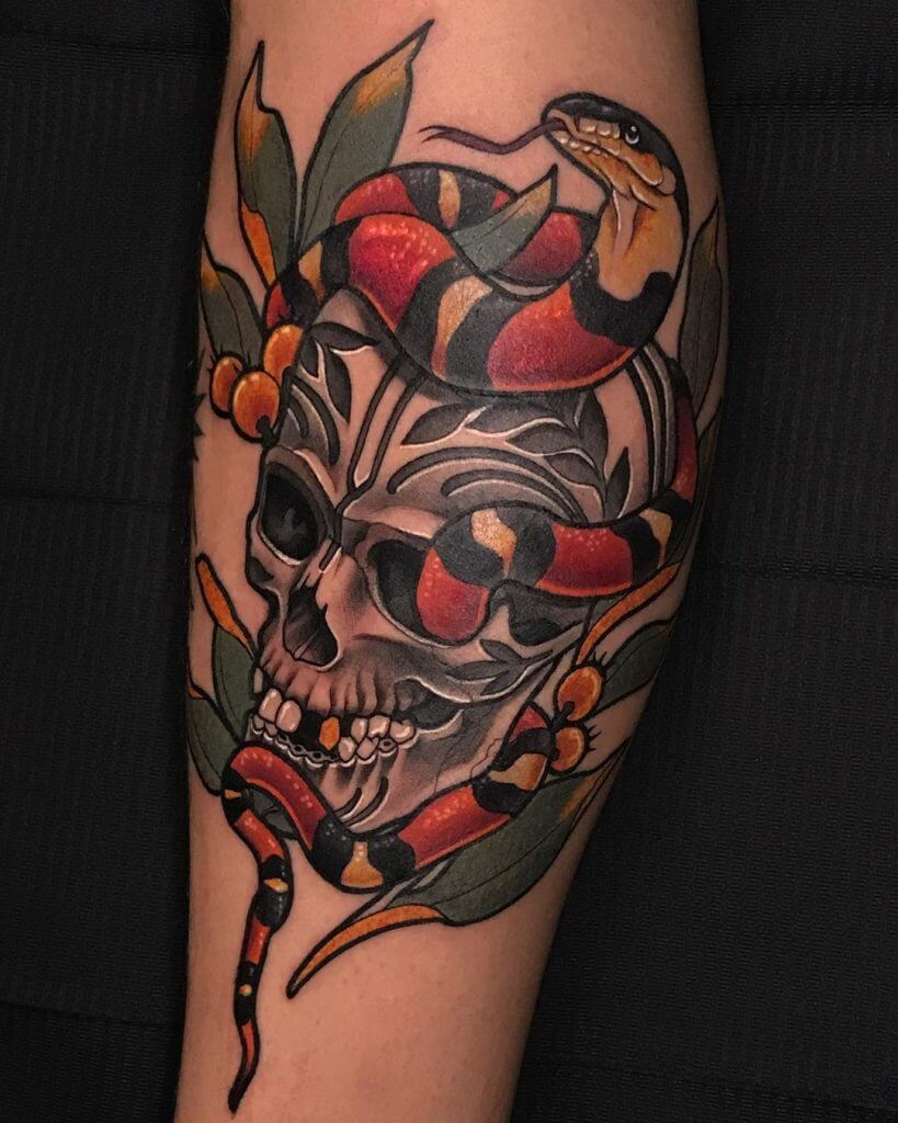 Color neotraditional tattoo with a skull, leaves and a snake on the calf
