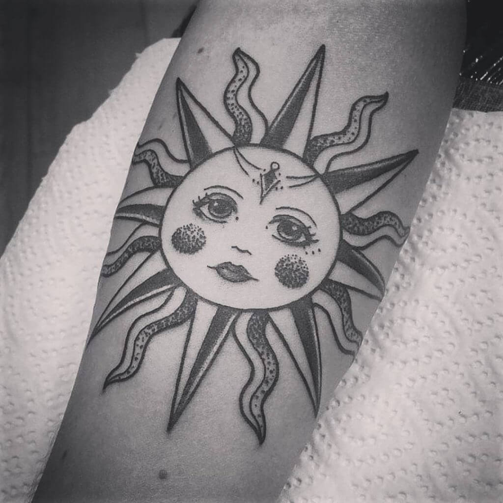 Black sun tattoo on the forearm