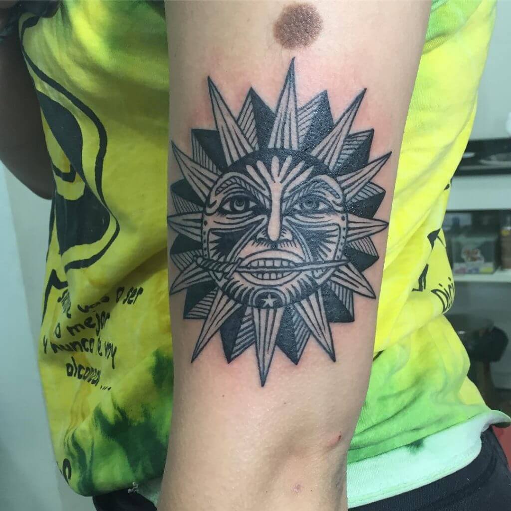 Black sun tattoo on the left arm