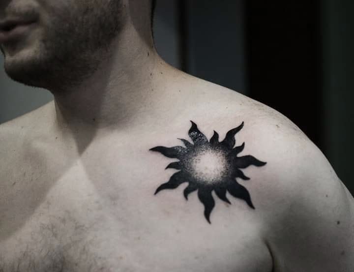 Black sun tattoo on the collar bone
