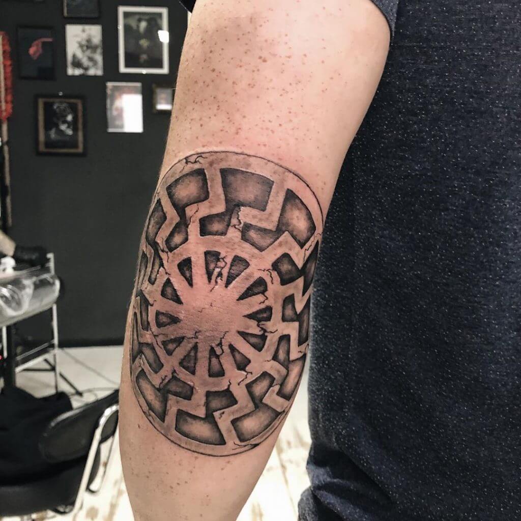 Black sun tattoo on the arm