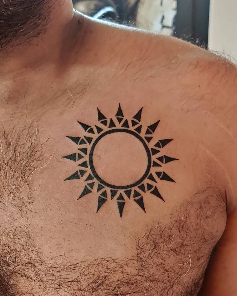 Tribal black sun tattoo on the chest