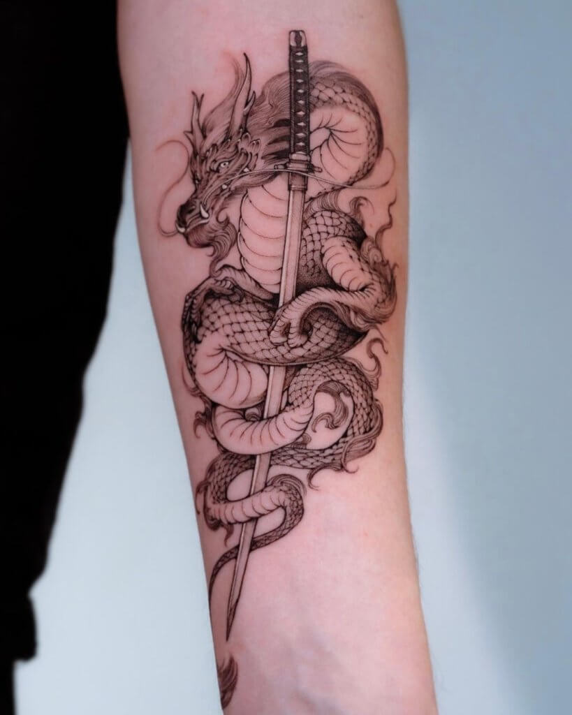 Dragon tattoo with sword on the arm 