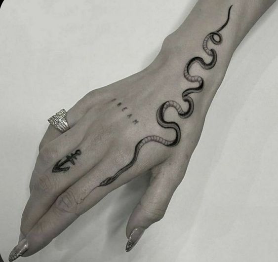 Fine line snake tattoo on the wrist