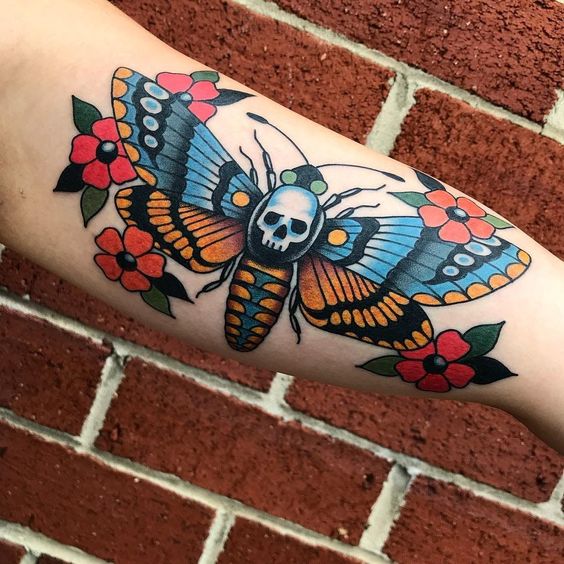 Traditional style moth tattoo on the left thigh