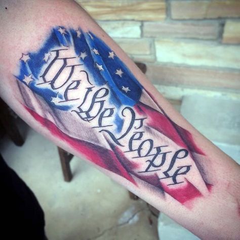 Forearm We the People tattoo with a flag