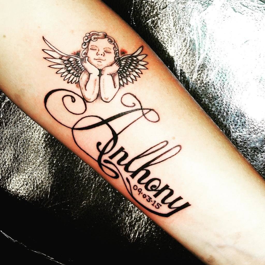 Forearm Cherub tattoo with a name and date