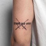 Trust No One lettering tattoo is a powerful message on the arm
