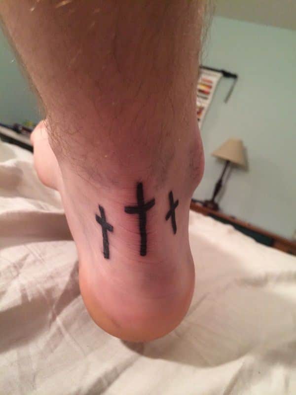 Simple and meaningful three crosses tattoo