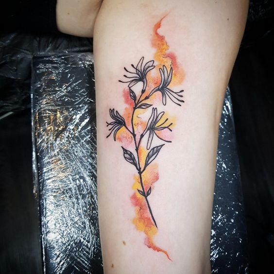 Intricate honeysuckle arm tattoo design that beautifully captures mixed watercolors and the allure of sweet attraction.